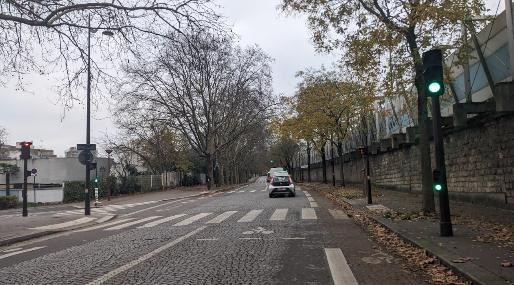 Rue Sigmund-Freud : chaussée pavée large, passage piéton, haut mur de pierre le long du trottoir